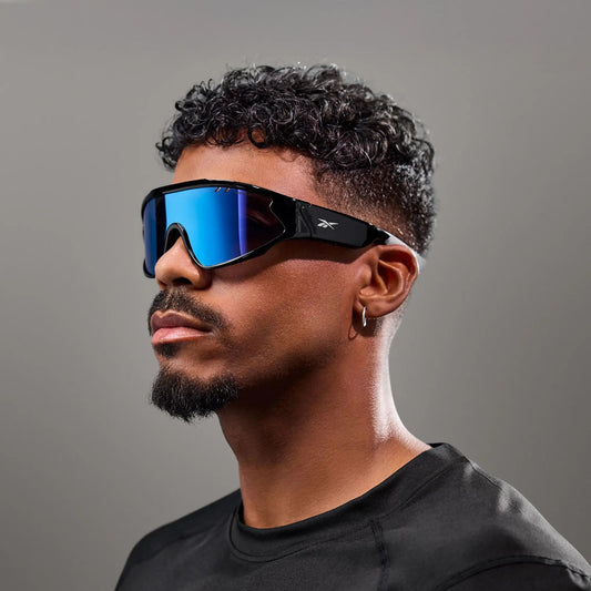 Model wearing Reebok Voltage Blue Mirror smart sports sunglasses, showing the frame and side arm.